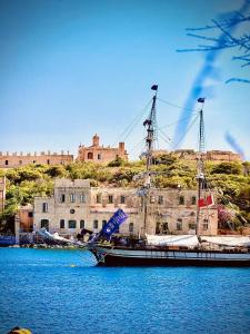 a boat sitting in the water in front of a castle at Prime Located Home by *The Sea* in Sliema