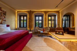 a bedroom with a bed and chairs and windows at Casa Di Paolo in Sibiu