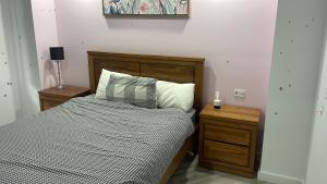 a bed with a wooden headboard and two night stands at Ballarat home in Ballarat