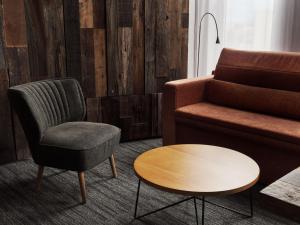 a living room with a couch and a chair and a table at ONE@Tokyo by insomnia in Tokyo