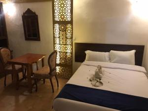 a bedroom with a bed and a table and a tableablish at Guest House in Luxor