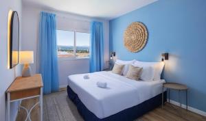 a bedroom with a large bed with blue walls and a window at Greek Village - Latchi הכפר היווני - כשר in Polis Chrysochous +95 photos