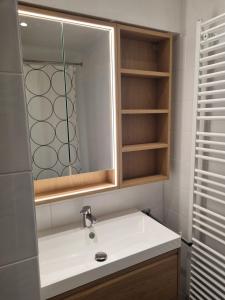 a bathroom with a white sink and a mirror at SeaStay - vernieuwde badkamer en interieur living in Knokke-Heist +8 photos
