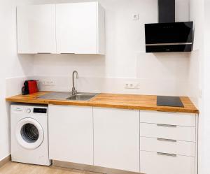 a white kitchen with a sink and a dishwasher at Apartaments l'Escala Centre in L'Escala