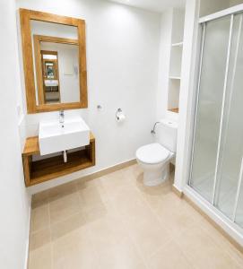 a bathroom with a toilet and a sink and a mirror at Apartaments l'Escala Centre in L'Escala