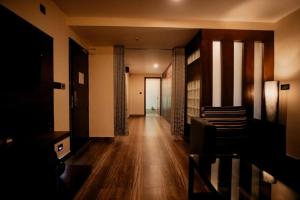 a hallway with wooden floors and a room with a door at Hotel New Indraprastha in Adūr