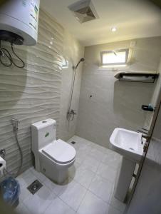 a bathroom with a toilet and a sink at شقة راقية 3 غرف نوم وصالة ومطبخ وحمامين حي باقدو a1 in Medina