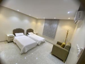 a bedroom with two beds and a couch at شقة راقية 3 غرف نوم وصالة ومطبخ وحمامين حي باقدو a1 in Medina