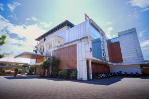 a building with a man standing in front of it at Hotel New Indraprastha in Adūr