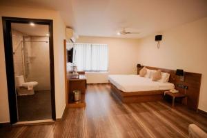 a bedroom with a bed and a walk in shower at Hotel New Indraprastha in Adūr
