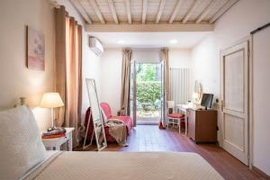a bedroom with a bed and a desk and a window at Cascina De' Fagiolari in Lastra a Signa +131 photos