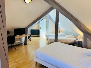 a bedroom with two beds and a desk with a television at Logis Hôtel Restaurant Volcan Sancy in Nébouzat