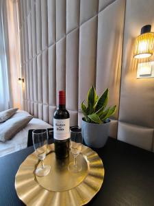 a bottle of wine and two glasses on a table at Place4You Studio w Sercu Ostródy in Ostróda