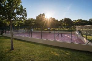 two people playing tennis on a tennis court at Kampaoh Mendigorría in Mendigorría