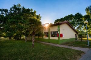 a green and white building with a palm tree at Kampaoh Mendigorría in Mendigorría