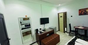 a living room with a couch and a television at Pandorax Hotel Oluku in Benin City