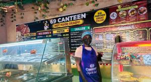 a woman standing in front of a food counter at Pandorax Hotel Oluku in Benin City