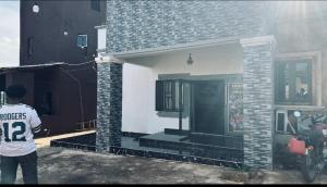 a man standing in front of a house at Pandorax Hotel Oluku in Benin City +4 photos