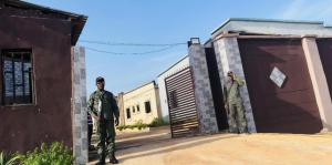 two men are standing in front of a garage at Pandorax Hotel Oluku in Benin City