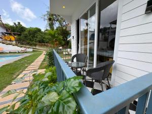 a porch with two chairs and a blue railing at Tvessa-A Boutiqe Hotel in Mandrem
