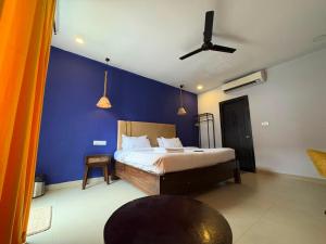 a bedroom with a bed with a blue wall at Tvessa-A Boutiqe Hotel in Mandrem