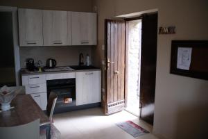 a kitchen with a door open to a kitchen with a table at Bruner Haus - Casa Vacanze in Castelmezzano