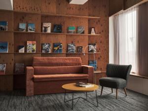 a living room with a couch and a chair and a table at ONE@Tokyo by insomnia in Tokyo