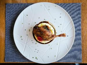 a white plate with a piece of food on a table at Pensiune & Restaurant Victoria in Păltiniş