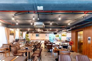 a restaurant with wooden tables and chairs in a room at Rico hotel Nha Trang in Nha Trang