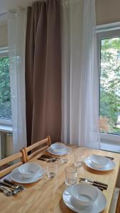 a wooden table with plates and glasses on it at Boarder City Center Apartment, Võidu tn 5, Apt 16, 4th Floor, Narva in Narva