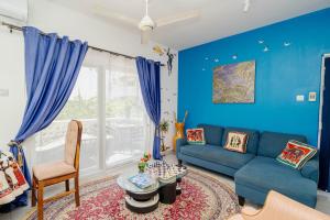 a living room with blue walls and a blue couch at Zanzibar,Fumbatown Cozy 1 bed Apartment in Fumba