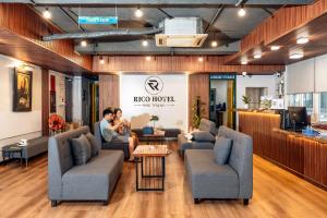 two people sitting on couches in a lobby at Rico hotel Nha Trang in Nha Trang +71 photos