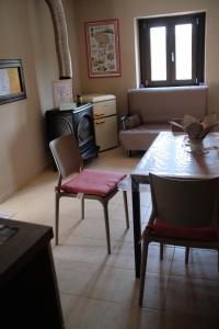 a living room with a table and chairs and a fireplace at Bruner Haus - Casa Vacanze in Castelmezzano +16 photos