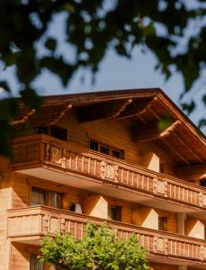 a large wooden building with a balcony at Hotel Brugger in Fulpmes