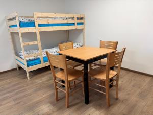 a table and chairs in a room with bunk beds at Ubytování ProDante in Ostrava
