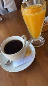 a cup of coffee and a drink on a table at Rolys House in Los Baños del Inca