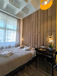 a bedroom with a large bed and a table at Place4You Studio w Sercu Ostródy in Ostróda