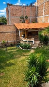 a backyard with a bench and a brick building at Rolys House in Los Baños del Inca