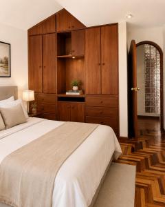 a bedroom with a large bed and wooden cabinets at Rolys House in Los Baños del Inca