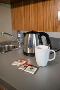 a tea kettle and a cup of coffee on a counter at Hotel Vaka in Brno