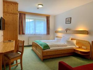 a bedroom with a bed and a desk and a chair at Heisshof in Schladming