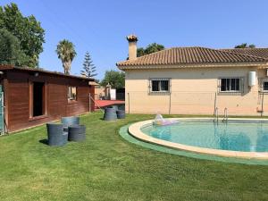 a yard with a swimming pool in front of a house at Finca La Talona, piscina in Cádiz