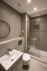 a bathroom with a toilet and a sink and a shower at Stylish Flat in Peterborough Centre in Peterborough