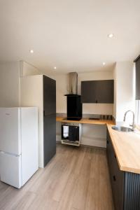a kitchen with a white refrigerator and wooden floors at Stylish Flat in Peterborough Centre in Peterborough