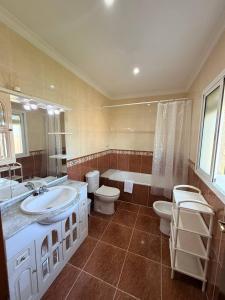 a bathroom with a sink and a toilet and a tub at Finca La Talona, piscina in Cádiz +44 photos
