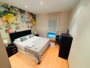 a bedroom with a bed with a flower mural on the wall at Teatro de Caesar Augusta in Zaragoza