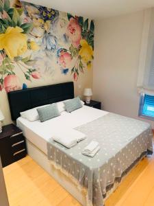 a bedroom with a bed with a flower mural on the wall at Teatro de Caesar Augusta in Zaragoza