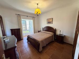 a bedroom with a bed and a pendant light at Finca La Talona, piscina in Cádiz