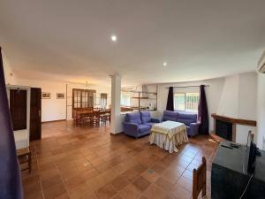 a living room with a blue couch and a table at Finca La Talona, piscina in Cádiz