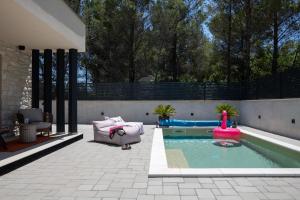 a backyard with a pool with a pink inflatable at Casa Palmera in Pridraga